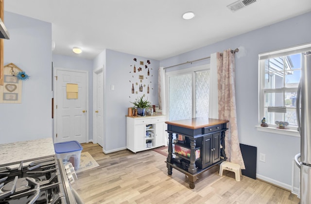 dining area featuring plenty of natural light, light wood-style floors, visible vents, and baseboards