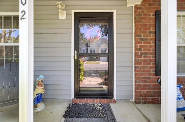 doorway to property featuring brick siding