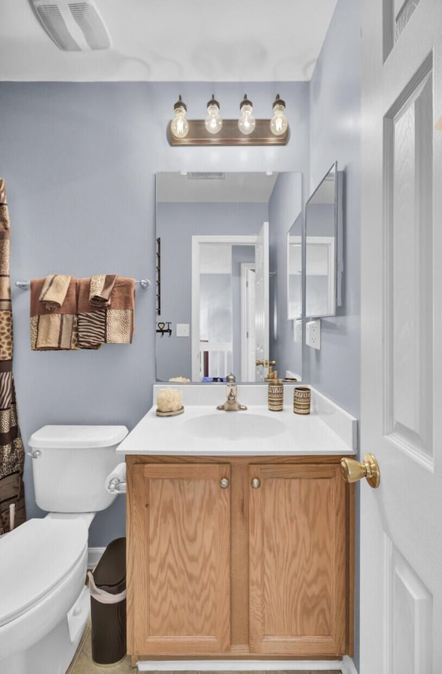 bathroom with visible vents, toilet, and vanity