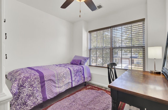 bedroom featuring wood finished floors, visible vents, and ceiling fan