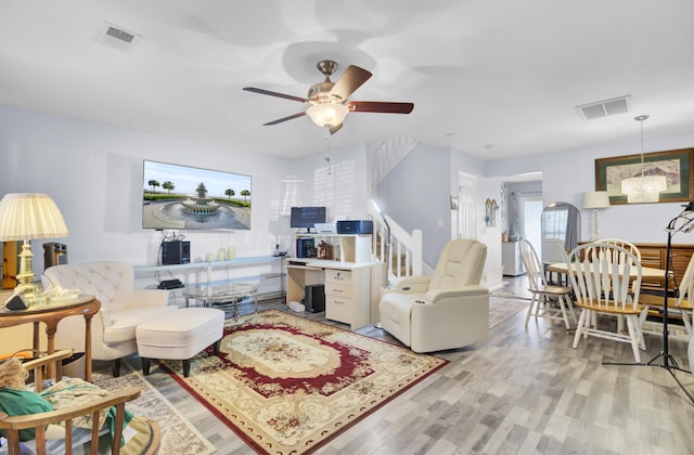 living area with visible vents, light wood-type flooring, and ceiling fan