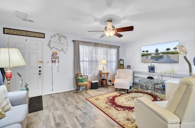 interior space with visible vents, a ceiling fan, and wood finished floors