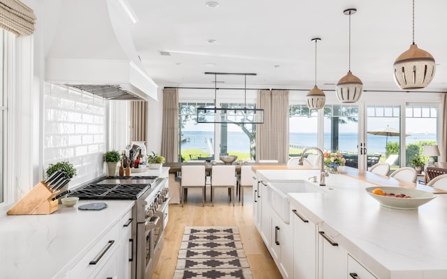202 Bank St, Mount Pleasant, SC 29464 - kitchen with a sink, high end stainless steel range oven, light wood-style floors, a center island with sink, and healthy amount of natural light