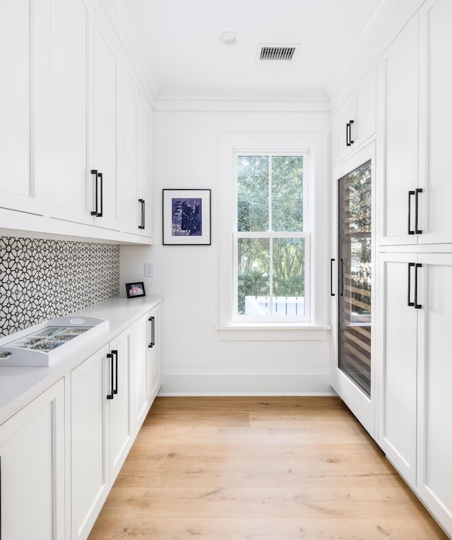 202 Bank St, Mount Pleasant, SC 29464 - bar with baseboards, backsplash, light wood-style floors, and crown molding