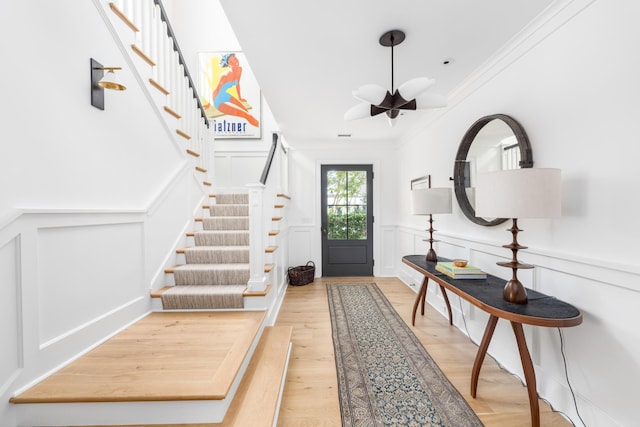 202 Bank St, Mount Pleasant, SC 29464 - foyer featuring a decorative wall, crown molding, stairway, light wood finished floors, and wainscoting