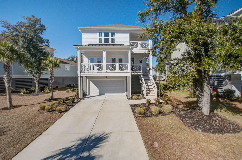 raised beach house with a garage and covered porch