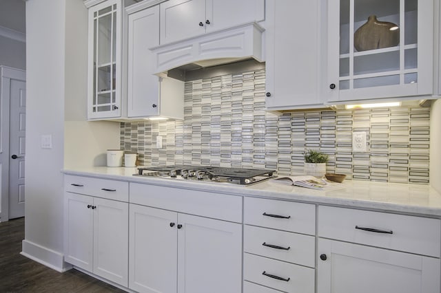 kitchen with stainless steel gas stovetop, premium range hood, white cabinets, backsplash, and light stone countertops