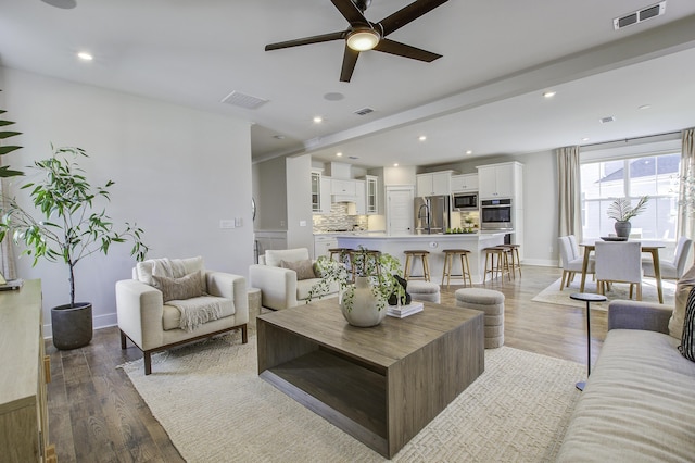 living room featuring ceiling fan and dark hardwood / wood-style flooring