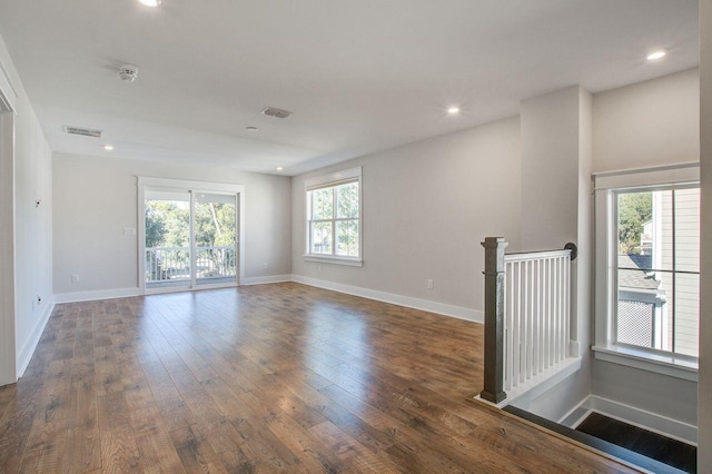 empty room featuring dark hardwood / wood-style flooring and a healthy amount of sunlight