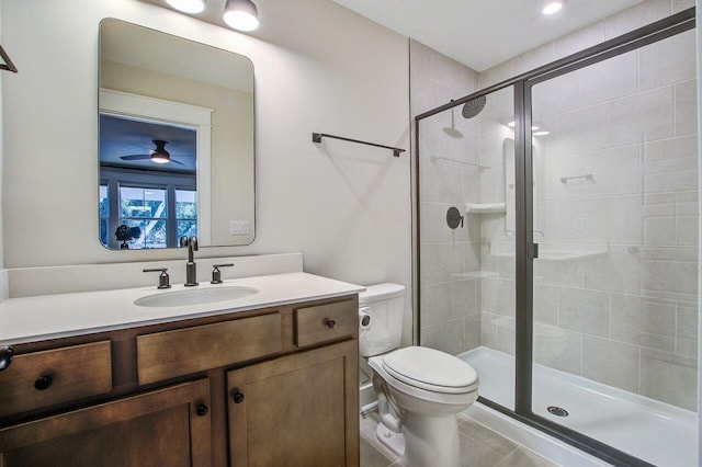 bathroom with tile patterned floors, vanity, toilet, walk in shower, and ceiling fan