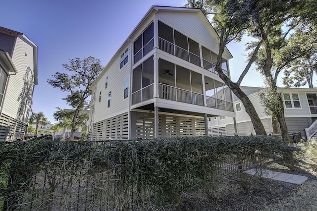 rear view of property with ceiling fan and a balcony