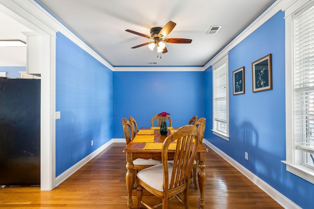 dining room featuring a healthy amount of sunlight, a ceiling fan, hardwood / wood-style floors, and visible vents