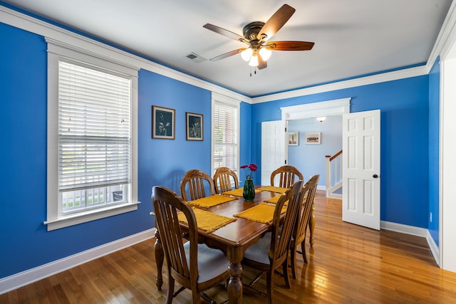 dining space featuring wood-type flooring, ceiling fan, visible vents, and baseboards
