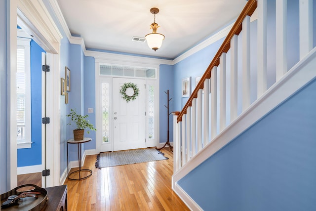 foyer entrance with light wood-type flooring, stairs, baseboards, and visible vents