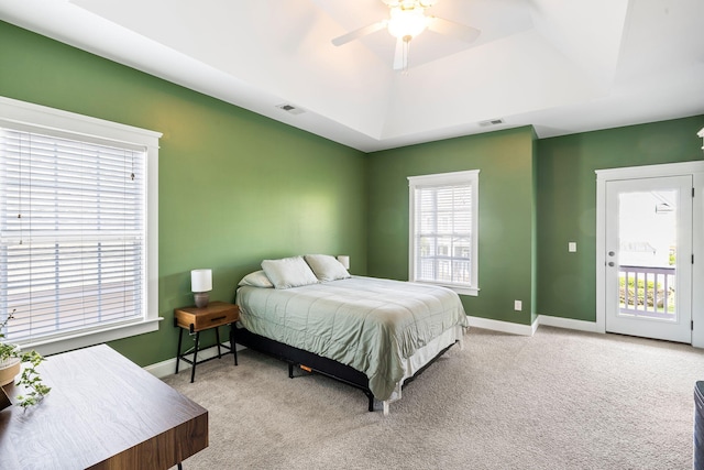 carpeted bedroom featuring a ceiling fan, baseboards, visible vents, and a raised ceiling