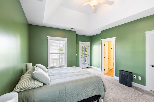 bedroom featuring carpet floors, visible vents, baseboards, a raised ceiling, and a ceiling fan