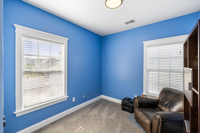 sitting room with a healthy amount of sunlight, baseboards, carpet, and visible vents
