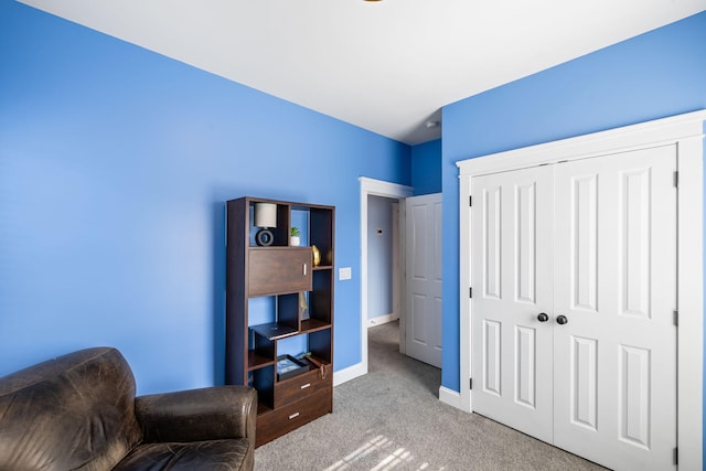 living area featuring carpet floors and baseboards