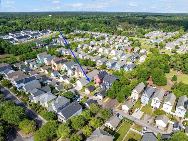 drone / aerial view featuring a forest view and a residential view