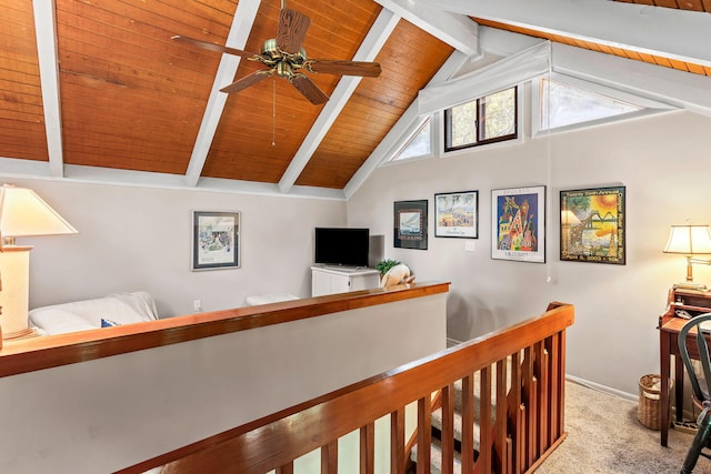 interior space featuring ceiling fan, lofted ceiling with beams, wood ceiling, and light carpet