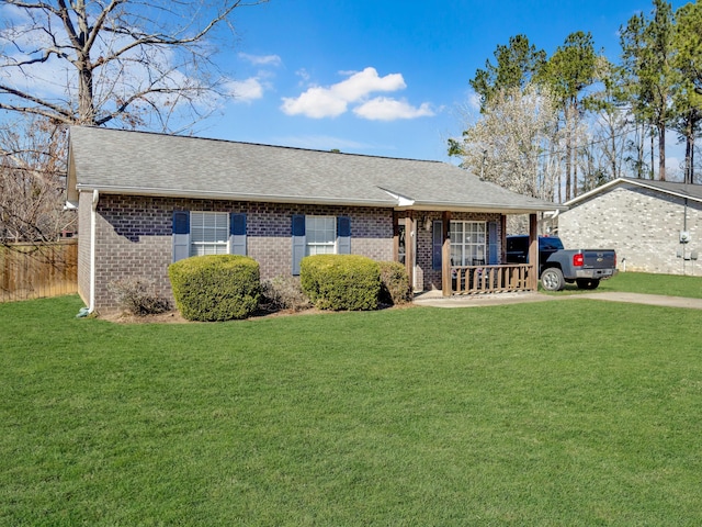 ranch-style house with a shingled roof, a front yard, brick siding, and a porch