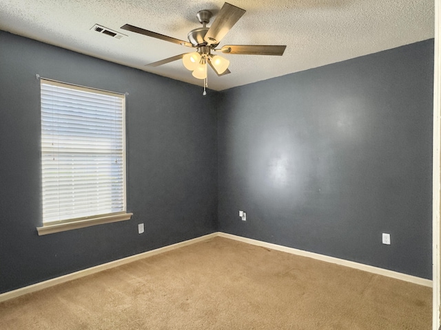 unfurnished room featuring a textured ceiling, carpet flooring, visible vents, and baseboards