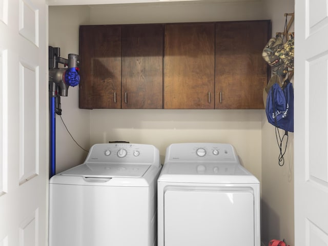 clothes washing area featuring cabinet space and washer and dryer