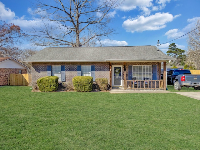 single story home with a porch, brick siding, fence, and a front lawn