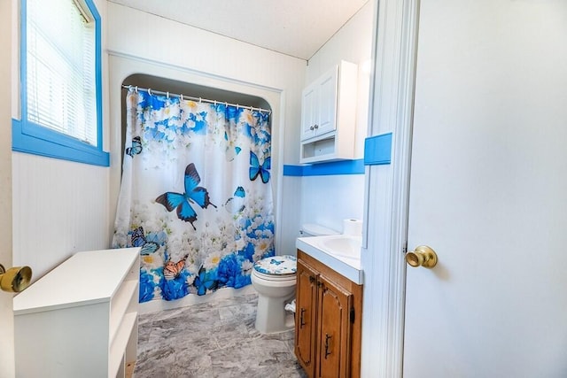 full bath with a shower with shower curtain, marble finish floor, toilet, and vanity