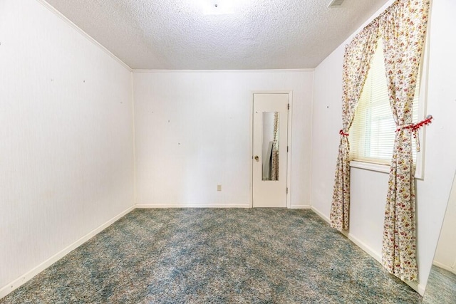 carpeted empty room with ornamental molding and a textured ceiling
