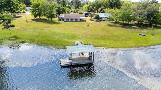 view of dock featuring a yard, a water view, and boat lift