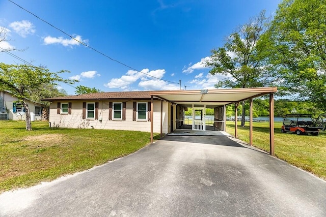 ranch-style house featuring aphalt driveway, a front yard, and an attached carport