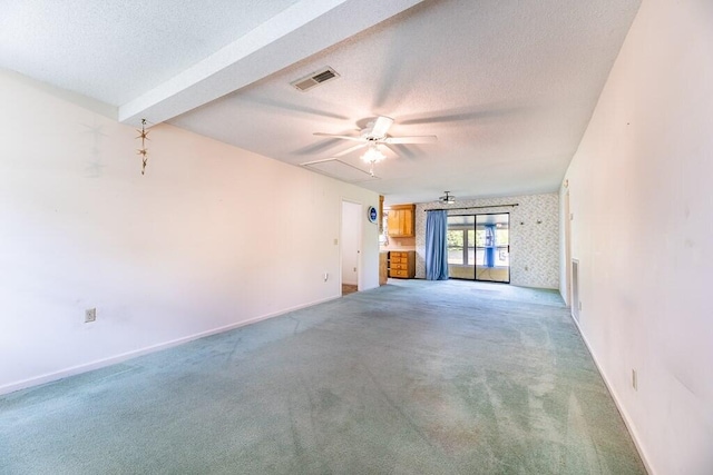 unfurnished living room with baseboards, visible vents, a textured ceiling, and light colored carpet