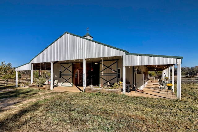 view of horse barn with a lawn and an outdoor structure