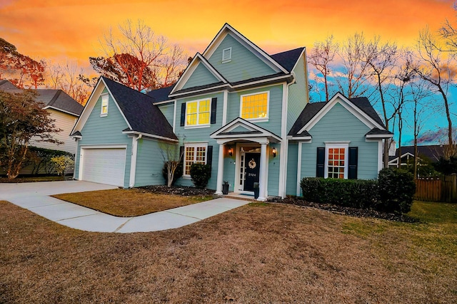 view of front of home with driveway, fence, and a yard