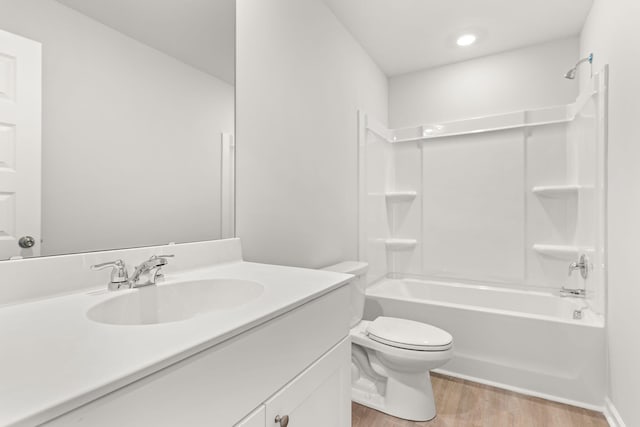 full bathroom featuring wood-type flooring, toilet,  shower combination, and vanity