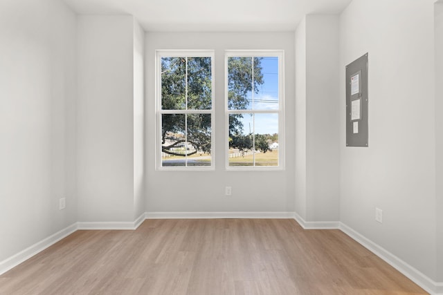 unfurnished room featuring electric panel and light wood-type flooring