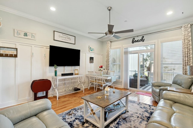 living room with hardwood / wood-style floors, ceiling fan, and crown molding