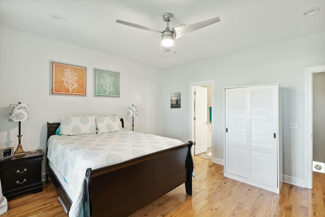 bedroom featuring ceiling fan, light hardwood / wood-style floors, and a closet