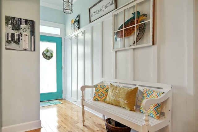 mudroom with light hardwood / wood-style flooring, a healthy amount of sunlight, and crown molding