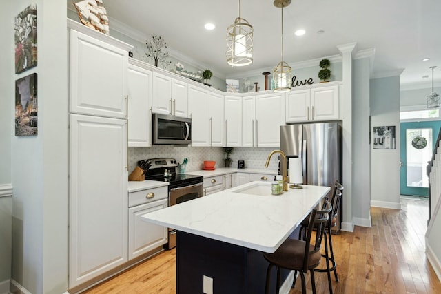 kitchen with a center island with sink, sink, white cabinetry, and stainless steel appliances