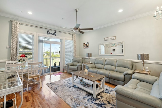 living room featuring wood-type flooring, ceiling fan, and ornamental molding