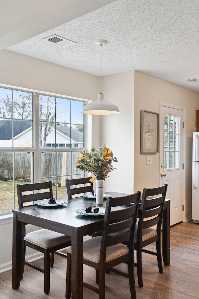 dining room featuring a textured ceiling and hardwood / wood-style flooring