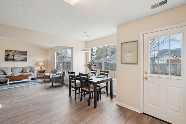 dining area with dark wood-type flooring and a textured ceiling