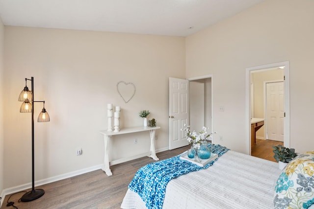 bedroom with hardwood / wood-style flooring and a high ceiling