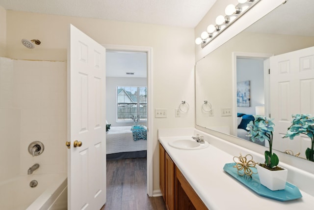 bathroom featuring shower / bathing tub combination, vanity, a textured ceiling, and hardwood / wood-style floors