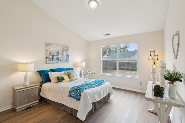 bedroom with wood-type flooring and vaulted ceiling