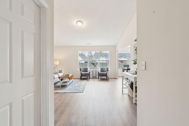 hall with hardwood / wood-style flooring and lofted ceiling