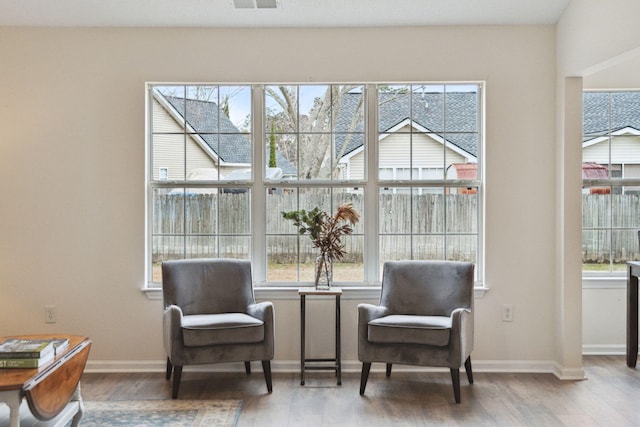 sitting room with wood-type flooring and a healthy amount of sunlight