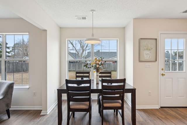 dining room with hardwood / wood-style flooring and a textured ceiling